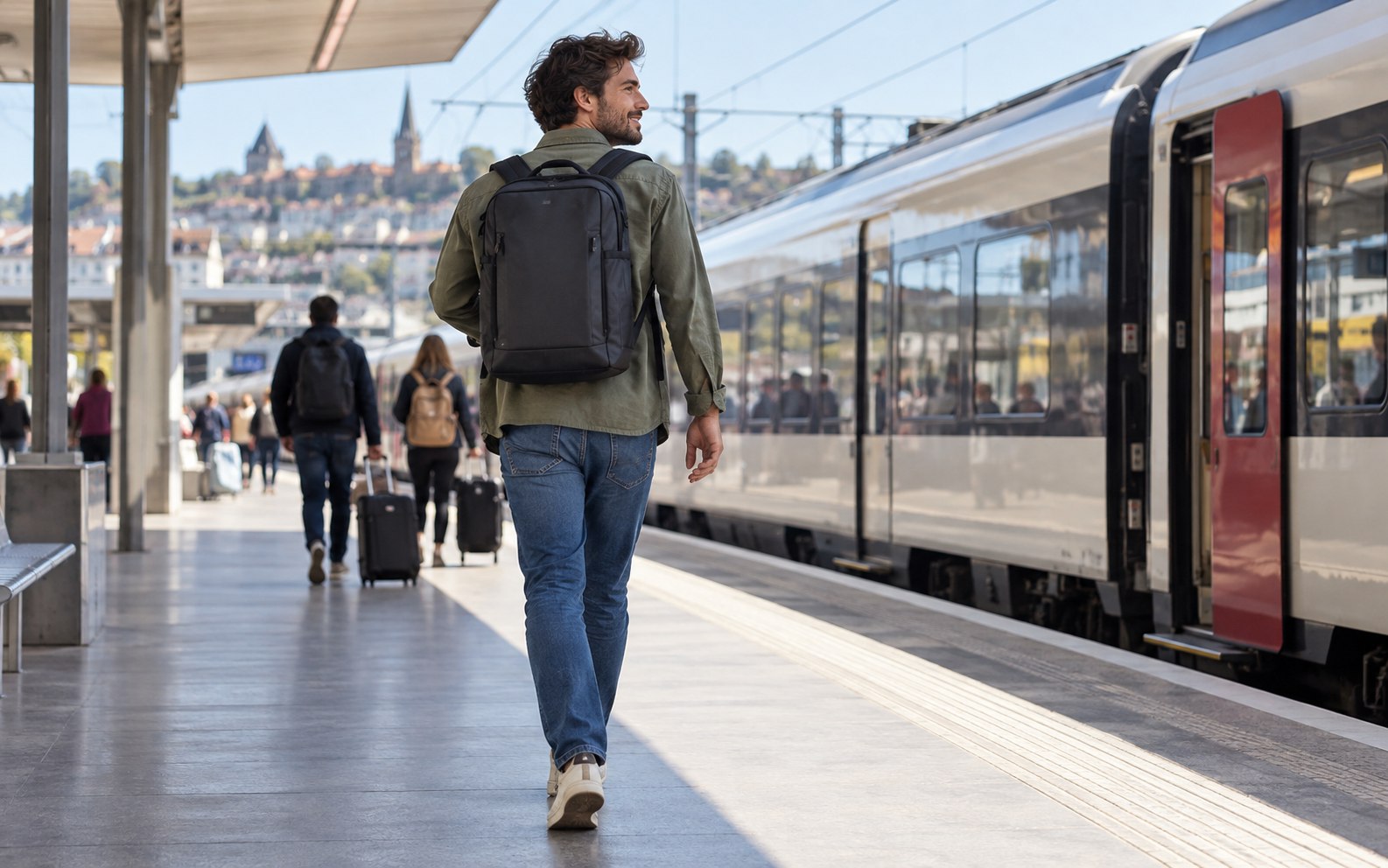 A traveler carrying a compact backpack while walking along a train platform
